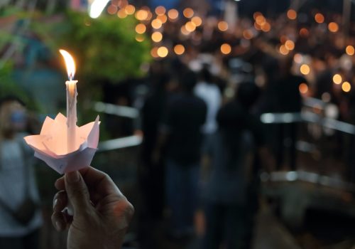 Hand of man hold candle flame light at night with bokeh background